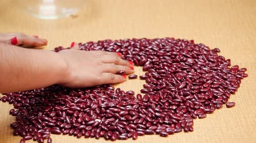 Hands Sorting and Spreading Kidney Beans on Table