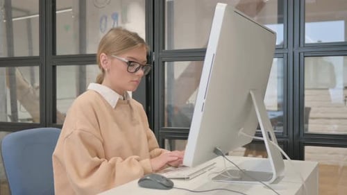 Woman in Glasses Working on Desktop in Office