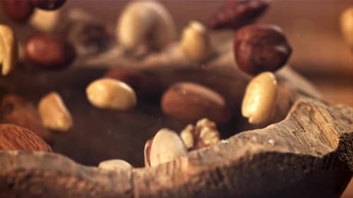 Different Nuts Fall Into a Wooden Bowl Filmed on a Highspeed Camera at 1000 Fps