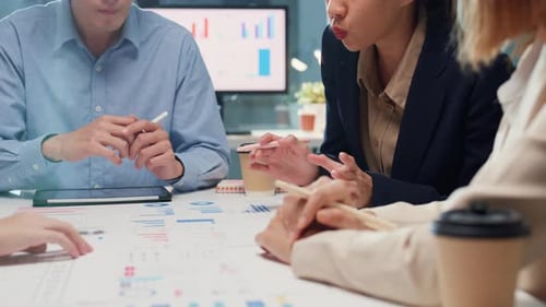 Business Team Meeting Discussing Charts and Data