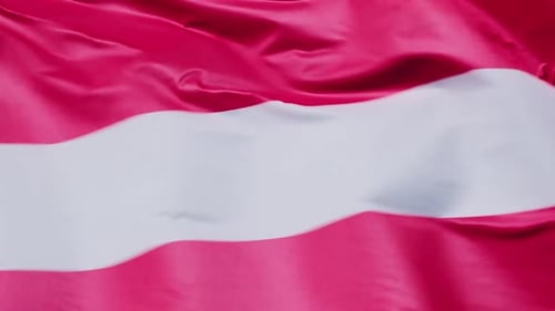 Nahaufnahme der lettischen Nationalflagge im Wind an einem sonnigen Tag