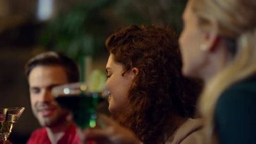 Closeup Young People Drinking Cocktails in Bar. Cheerful Friends Clinking Glasses At