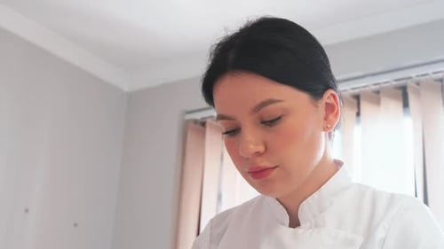 Young Woman Looking Down Indoors with Natural Light