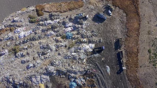 Aerial View of Landfill with Trucks Disposing Trash