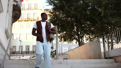 Man Walks Down Stairs in Urban Environment