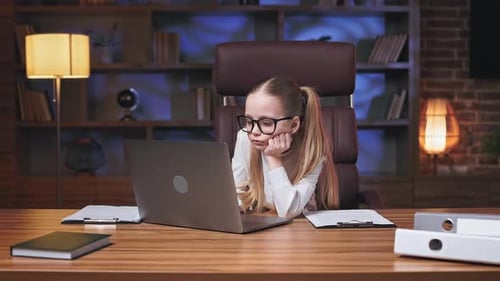 Gelangweiltes Kind schaut Webinar auf Laptop und macht im Büro ein Nickerchen