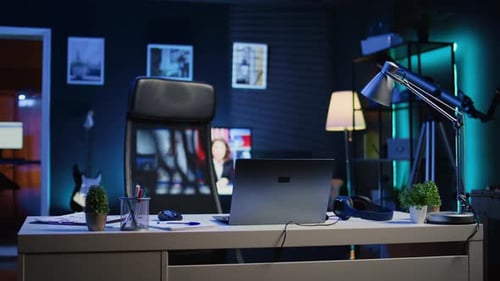 Home Office Desk in Front of Smart TV Displaying News Program Broadcasting