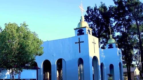 A Reveal Shot Of The White Orthodox Church Building Surrounded By Trees And A Clear Sky