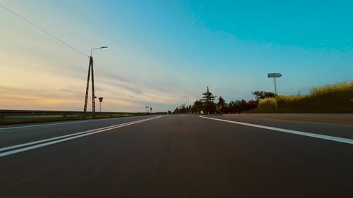 Driving Along Open Road at Sunset With Golden Light and Long Shadows Breathtaking POV View