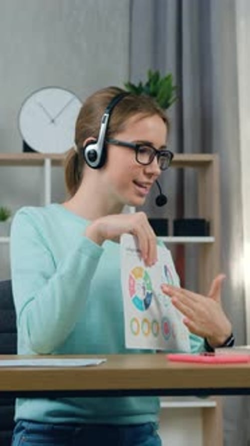 Close Up of Goodlooking Satisfied Skilled Young Girl in Headset Which Sitting at Her Workplace at