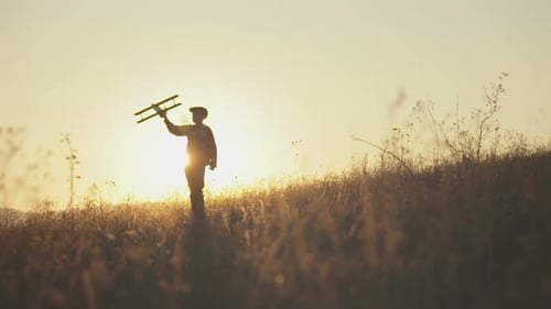 Child Holds Toy Plane in Sunrise Field