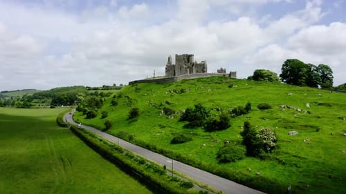 Drone shot up and over a castle in Ireland's rural countryside.