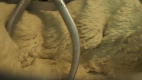 Industrial Mixer With wheat Dough rotating in bakery,close up
