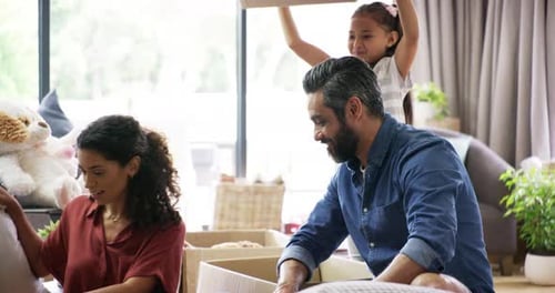 4k video footage of a little girl emptying a box of foam peanuts on her parents on moving day
