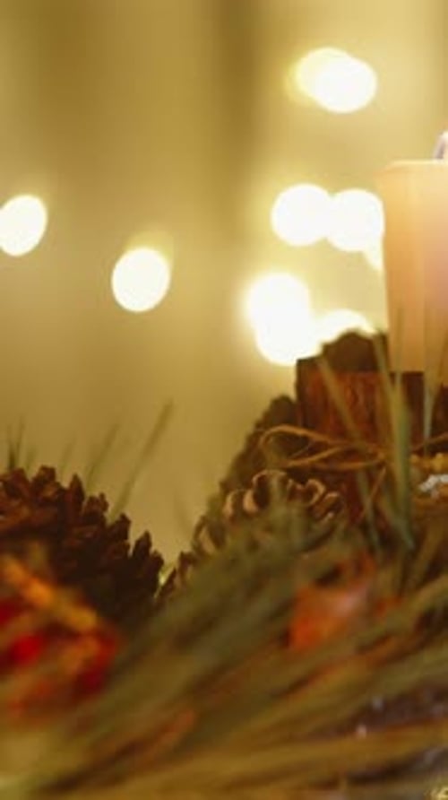 Lit Candle and Holiday Wreath at Night