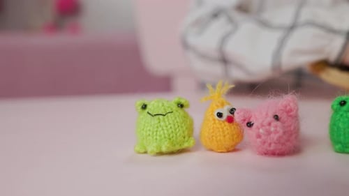 Mädchen spielt mit kleinen gestrickten Tierspielzeugen in einem Zimmer zu Hause