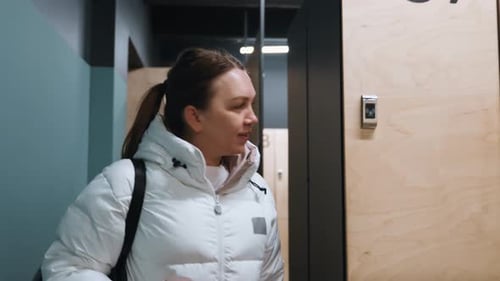 Un participant à une installation sportive choisit un casier pour la préparation du match Un participant arrivant au centre sportif