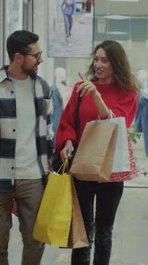 Couple with Shopping Bags Walking in Mall Together