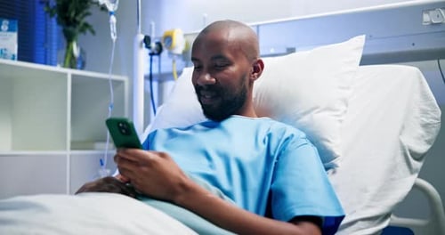Phone, smile and black man in bed at hospital for typing message, medical update and recovery