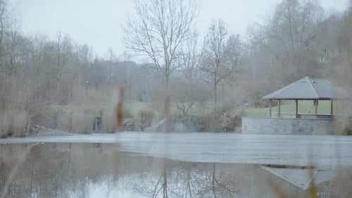 Focus pull on a frozen lake with a bridge and a lonely pier in a winter atmosphere