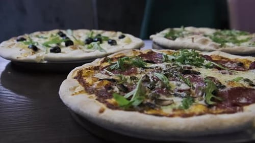 Lots of Pizzas on the Table in a Pizzeria