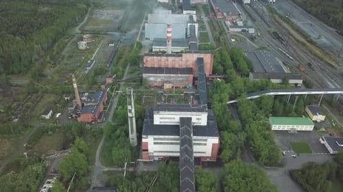 Industrial Plant Emitting Smoke in a Forest Area