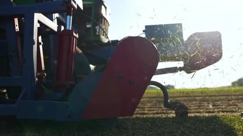 Tractor Processing Grass in Sunny Field