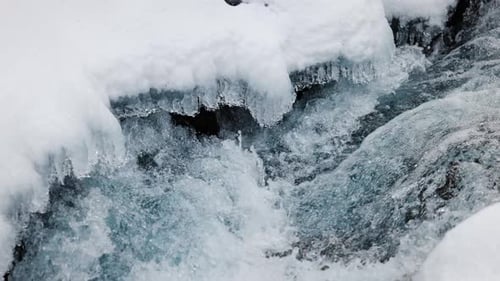River Stream at Winter Snow Forest in the Mountains