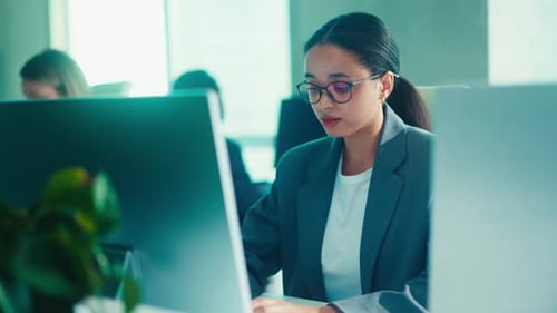Professional Woman Typing in a Bright Modern Office