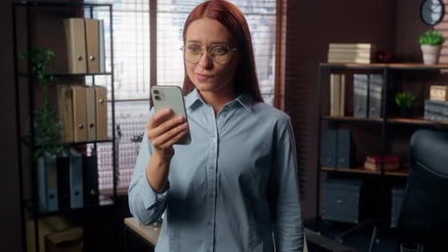 Excited Businesswoman Celebrating Good News on Smartphone in Modern Office