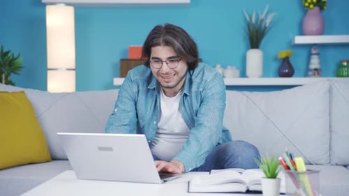 Young Man Working at Home on Laptop