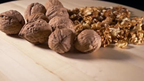 Walnuts and Shelled Walnuts on Wood Surface
