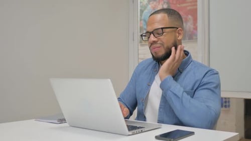 Adult Massages Neck While Working at Laptop