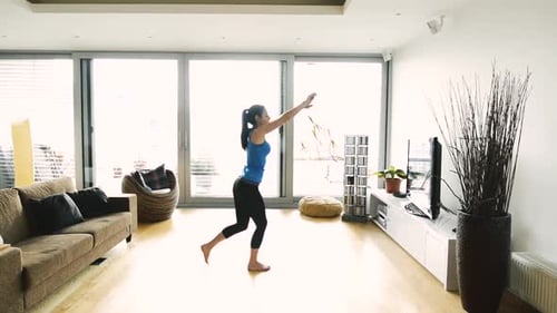 Woman Exercising and Stretching in Bright Living Room