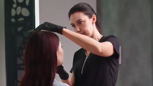 Beautician Applying Makeup with Brush in Beauty Salon