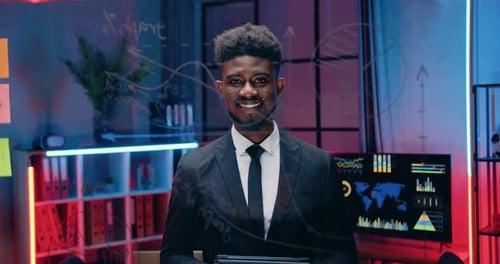 Business portrait of african american man which posing on camera in evening office behind glass wall
