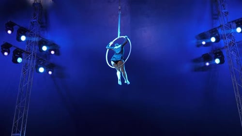 Acrobat Balances on Suspended Aerial Hoop Under Blue Lights