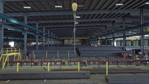 Aerial ascend from steel beams in warehouse floor along overhead bridge crane carry chain swinging
