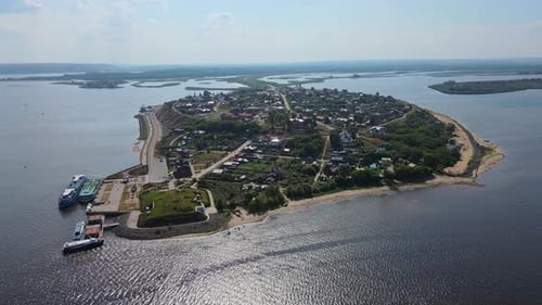 Aerial View of Coastal Settlement Highlighting Waterfront Community with Boats Along Shoreline