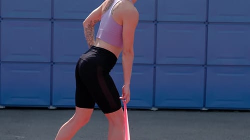 Athletic Woman Exercising With Resistance Band Outdoors