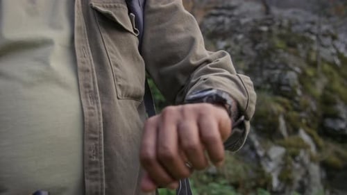 Adult Checks Watch Outdoors in a Natural Setting