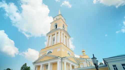 Low angle view of yellow Cathedral building on a blue cloudy summer sky background