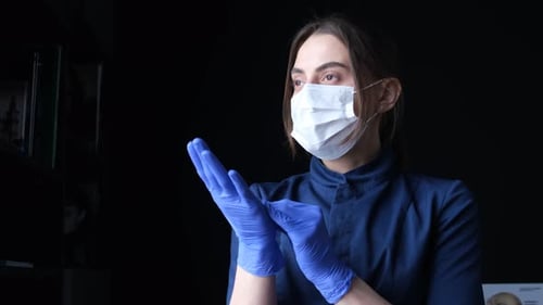 Woman with Mask and Gloves in Dark Setting