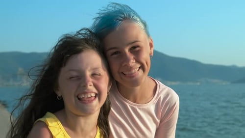 Two Happy Young Girls Posing by the Ocean