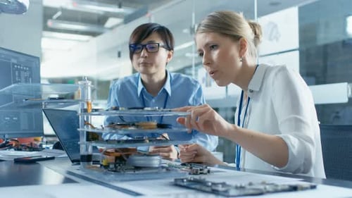 Zwei Computeringenieure wählen Leiterplatten aus, mit denen sie arbeiten möchten. Technologisch im Hintergrund