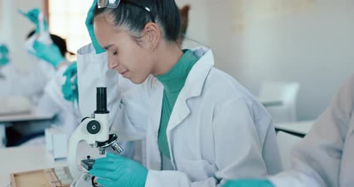 Young Woman Works in Science Lab with Microscope