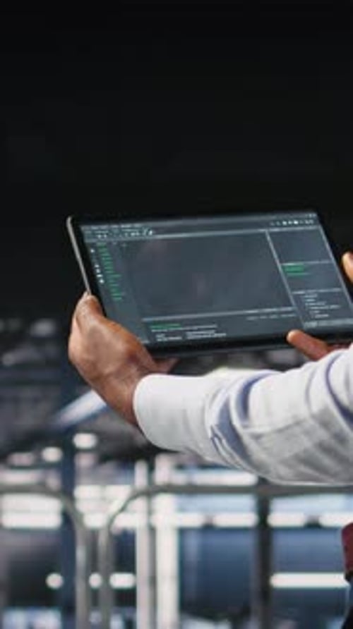 Vertikale Video-Nahaufnahme eines Rechenzentrumsprogrammierers, der sich Code-Debugging-Tools auf dem Tablet ansieht