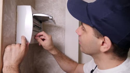 Man Working on Electrical Box in Home