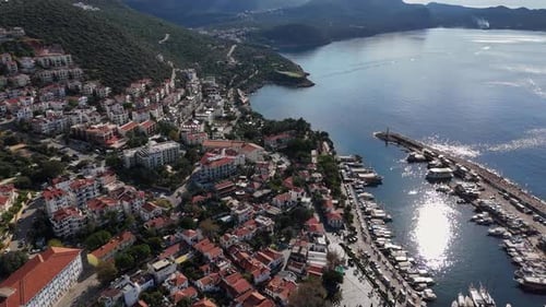 Luftaufnahme einer Küstenstadt mit Jachthafen und grünen Hügeln, Kas, Türkei