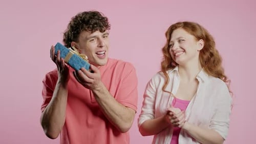 Young Couple Celebrating with Gift in Studio